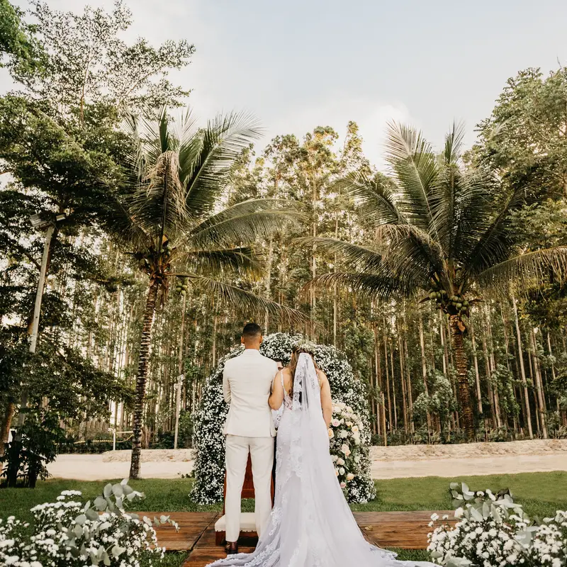 Bride and groom at an outdoor wedding ceremony altar, a moment guests capture and share to the host's Google Drive
